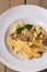 Tagliatelle vegetarian Pasta Dish with Mushrooms decorated with basil. Delicious lunch with pasta and white mushrooms