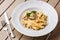 Tagliatelle vegetarian Pasta Dish with Mushrooms decorated with basil. Delicious lunch with pasta and white mushrooms