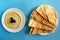 Tahini sauce with pita bread on blue background. Flat lay, top view. Hummus with olives and  flatbread.