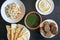 Tahini sauce, pita bread, rice with vermicelli, falafel and molokhia soup  on dark wooden table