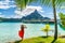 Tahiti travel holiday luxury hotel vacation tourist woman walking on Bora Bora island beach with view of Mt Otemanu in