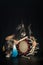 Taiko drummer in a wig and a demon mask on stage squarts with drumstick and drum and listen. Demon from