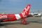 The tail of the plane of Thai Airasia, Airbus A320 is parked on the parking lot and against the passenger boarding staircase.