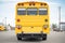 tail view of a yellow special needs bus showing hazard lights