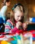 Tailor art workshops for children - a girl sewing felt decorations