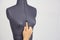 Tailor hand gently change the size of the breast on a female sewing mannequin, gray background, copy space