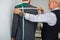 Tailor Measuring Back of Client to Make Suit