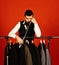 Tailoring and lack of work concept. Man with beard by clothes rack, Designer leans on hand near custom jackets.