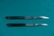 tainless steel scalpel handle number 3 and 4 with blade on surgical green drape fabric