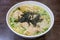 Taiwanese minced pork wonton noodle soup with seaweed on wooden table