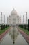 Taj Mahal at dawn, reflected in the clear water. Stillness in the morning.