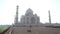 Taj Mahal front view from outdoor patio, with people passing.