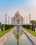 Taj Mahal front view reflected on the reflection pool, an ivory-white marble mausoleum on the south bank of the Yamuna river in Ag