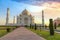 Taj Mahal medieval white marble mausoleum at sunrise with moody sky at Agra India