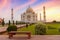 Taj Mahal white marble mausoleum at sunrise with moody sky at Agra India