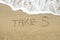 Take 5 written on sand