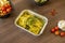 Take away aluminum tray with recipe for ravioli stuffed with meat with pesto sauce