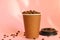 Take away coffee cup full of coffee beans on pink background. Good morning, coffee energy concept.