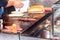 Take away fast food kiosk. Unidentified man preparing hot dogs. Street food market Selective focus