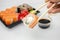 Take away sushi in plastic containers, philadelphia rolls and unagi maki, soy sauce, pink ginger, wasabi, sushi delivery concept
