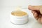Take golden under eyes patches with special spoon from a white container, anti aging skin care, white wet background