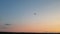 Take off the plane in the distance against the background of sunrise or sunset. Silhouette of an airplane. Airplane in