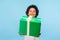 Take this present! Happy generous good-natured little boy with curly hair giving gift box