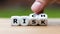 Take a risk and getting rich concept. Hand turns dice and changes the word `risk` to `rich`.