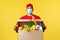 Takeaway delivery, covid-19 quarantine and groceries concept. Happy smiling courier in red uniform and medical mask