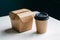 Takeaway duo Kraft paper box with hinged lid and cylindrical cup with black lid