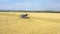 Taken from a drone, a gray harvester drives through a field. Russia