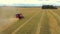 Taken from a drone, a red harvester drives through a field. Russia, Bashkortostan