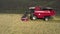 Taken from a drone, a red harvester drives through a field. Russia, Bashkortostan