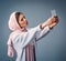 She takes the perfect selfies. Studio shot of an attractive young woman taking selfies while standing against a grey