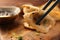 Taking delicious gyoza (asian dumpling) from wooden board, closeup