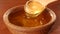 Taking honey by using spoon in wooden bowl, slow