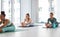 Taking a moment during the day for ourselves. a diverse group of women practising yoga and holding a seated forward fold