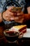 Taking photo with black coffee and red velvet cake on dark wooden table with smartphone with man hand. for up to social network.