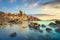 Talamone rocky beach and medieval fortress at sunset. Maremma Argentario, Tuscany, Italy