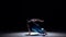 Talanted dancer in blue trousers starts dancing breakdance, on black, shadow, slow motion