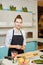 Talented attractive chef is holding green and posing to the camera