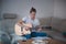 Talented boy playing a wooden acoustic guitar in a lighted room. Blonde Man aged 20-29 strums guitar and sings from hymn book on