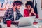 Talented creative couple sitting in front of laptop working together