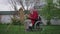 Talented creative disabled old man painting on easel in spring summer garden on backyard in slow motion. Side view wide