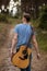 Talented guitarist playing forest hiking concept.