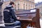 A talented homeless musician plays the piano in the street to earn some money