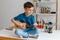 Talented kid playing soprano ukulele sitting on desk