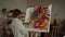 Talented woman painting in studio. Inspired painter using oil paints indoors.