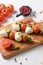 Talian food - caprese salad - skewer with tomato, mozzarella and basil, pesto sauce, mediterranean diet concept on old chopping