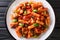 Talian Pasta Tortiglioni with eggplant, zucchini, pepper and basil in tomato sauce close-up in a plate. Horizontal top view